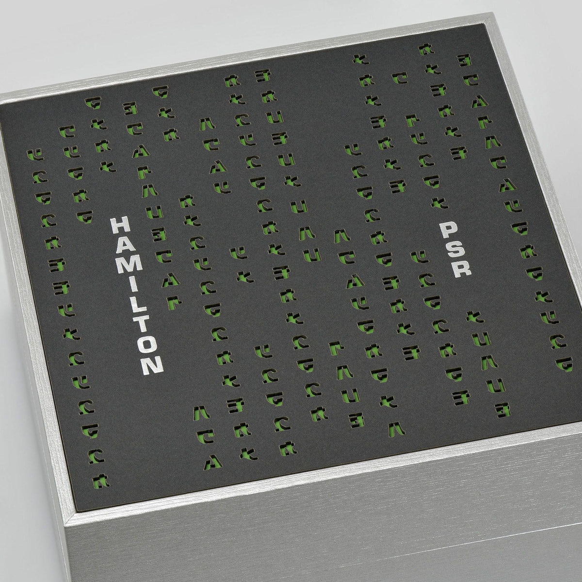 Hamilton watch presentation box insert with green letter-pattern print on dark card