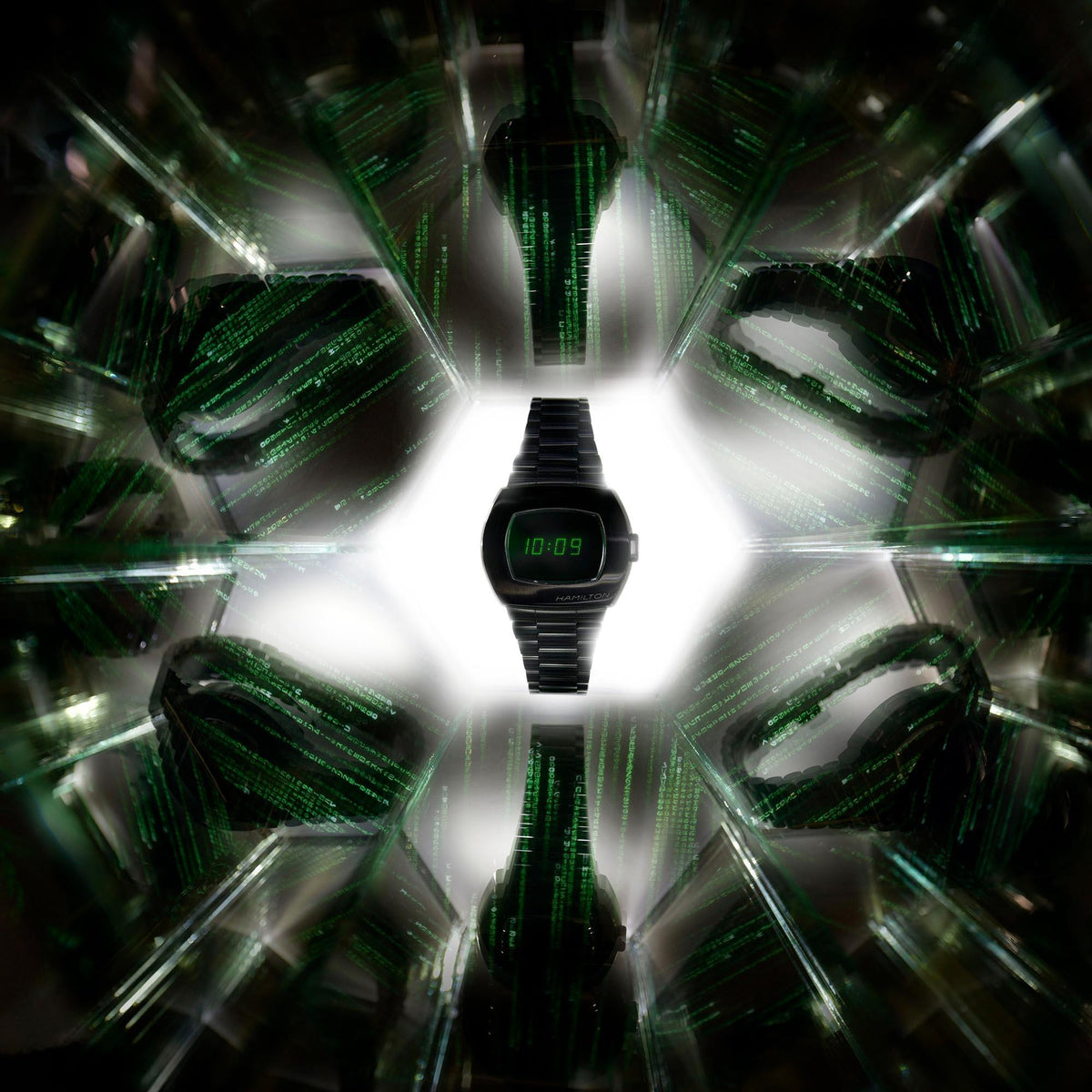 Hamilton men's digital watch centered view, black case and green LCD on steel bracelet