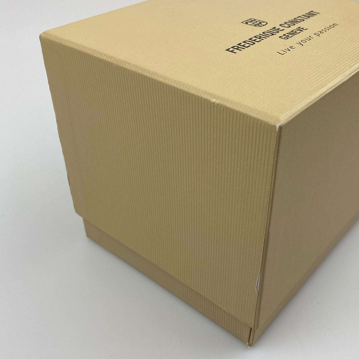 Damaged cardboard watch box corner with printed brand text on lid