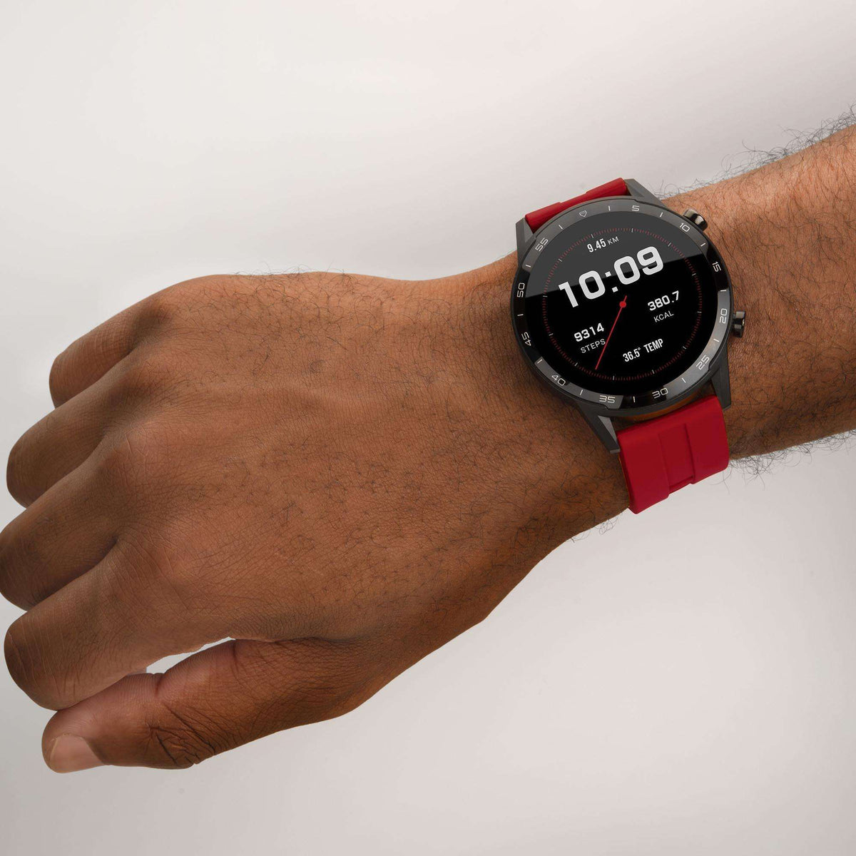 Black smartwatch with red silicone strap, round interactive dial on wrist