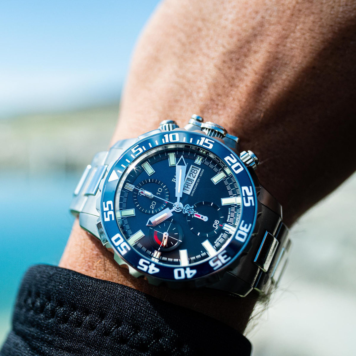 Men's steel automatic watch with blue dial, luminous hands, and chronograph subdials