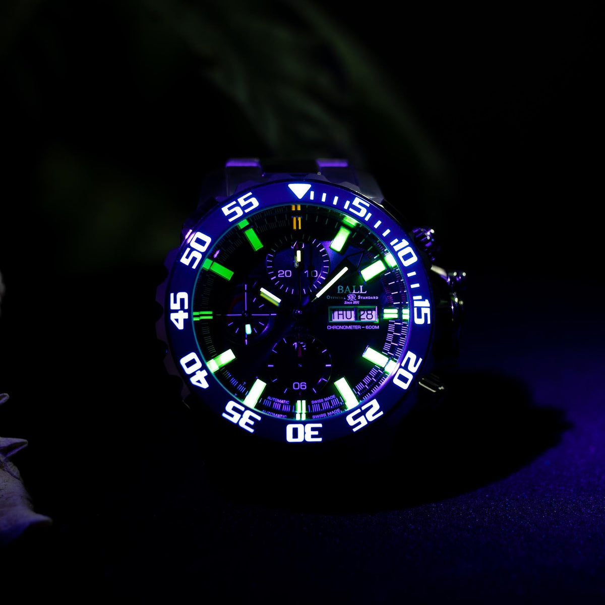 Men's steel automatic watch with blue dial, luminous green markers, and chronograph layout