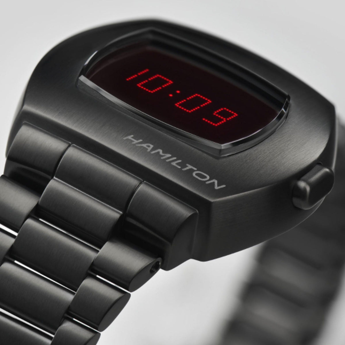 Black watch face with red LED digits and Hamilton logo on metal case