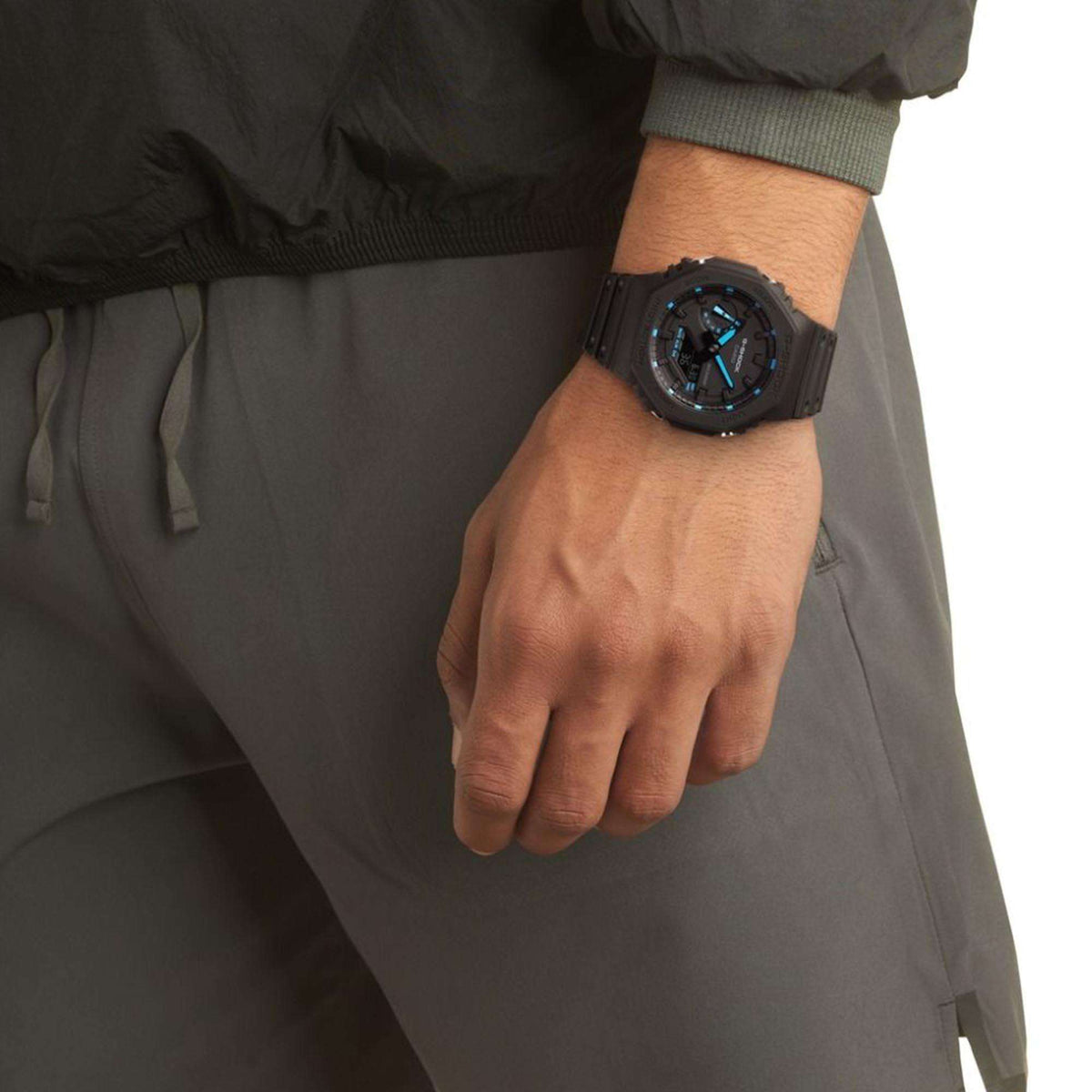 Men's G-Shock digital watch on wrist with blue-lit display and black resin strap
