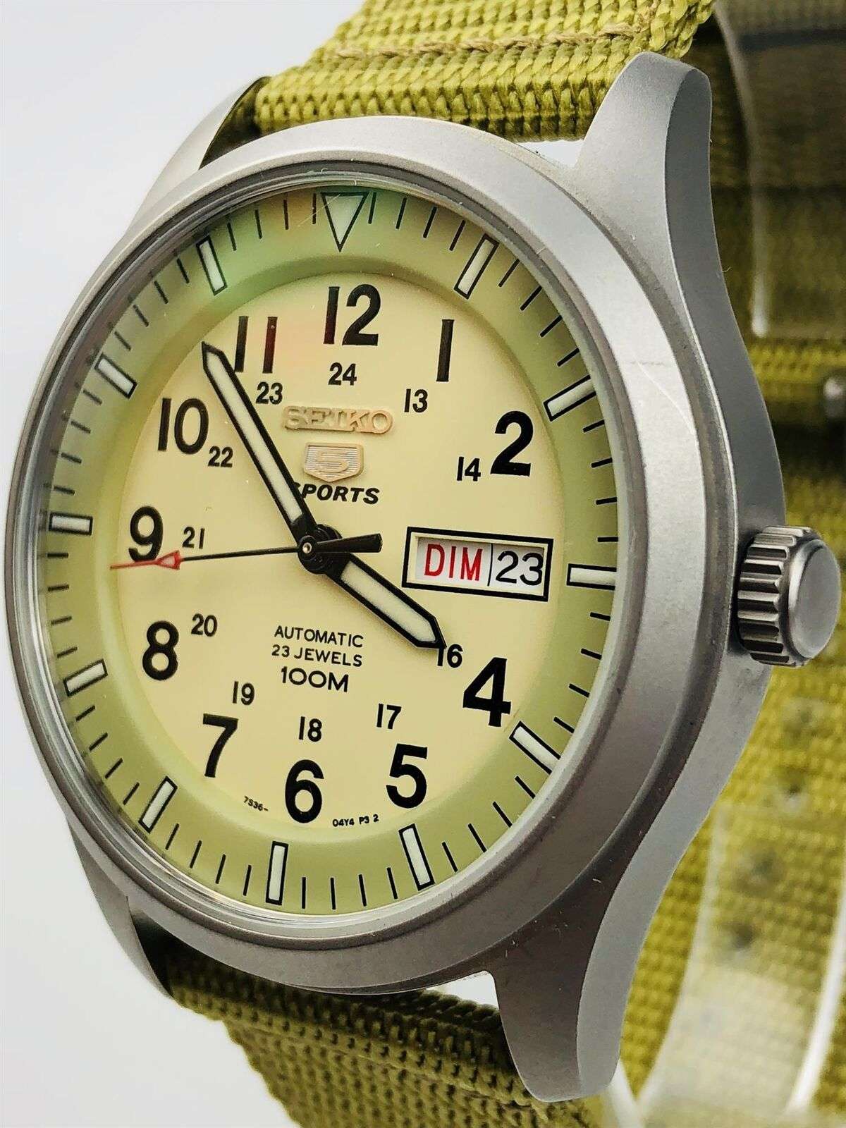 Front side view of sports watch with cream dial, olive strap, and right-side crown