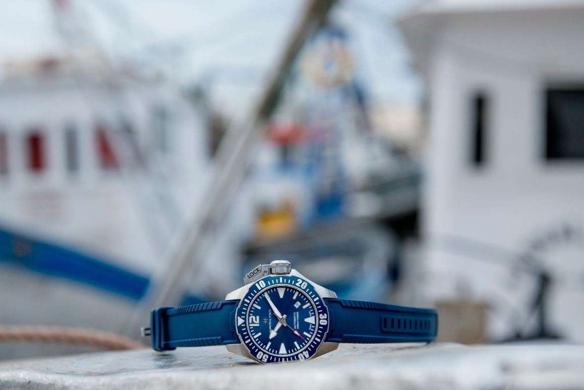 Hamilton blue dial diver watch with blue silicone strap on dock
