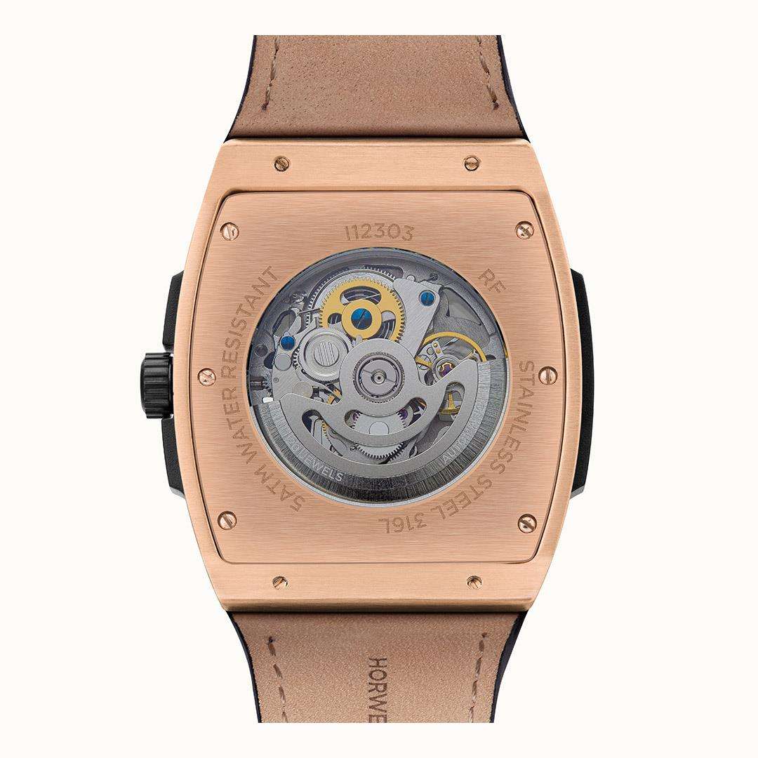 Rose-gold watch case back with clear window showing automatic movement and leather strap.