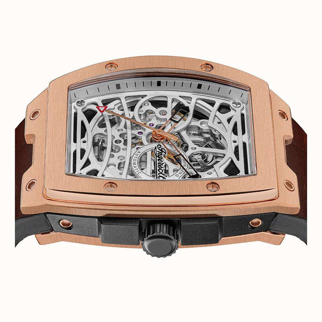 Rose-gold skeleton watch front with visible gears through open dial and dark strap.