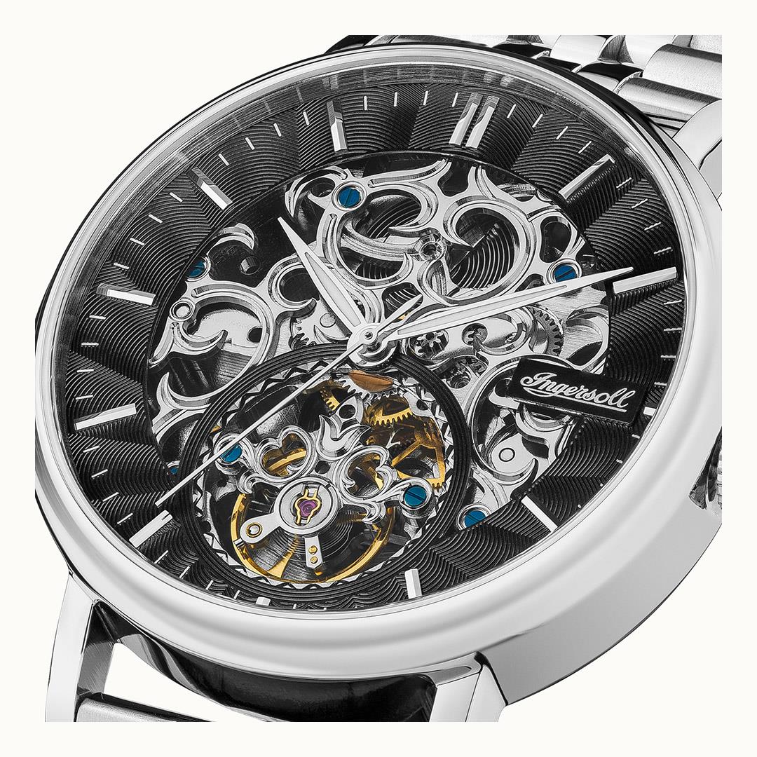 Close-up of automatic watch skeleton dial with silver gears, blue details, and luminous hands