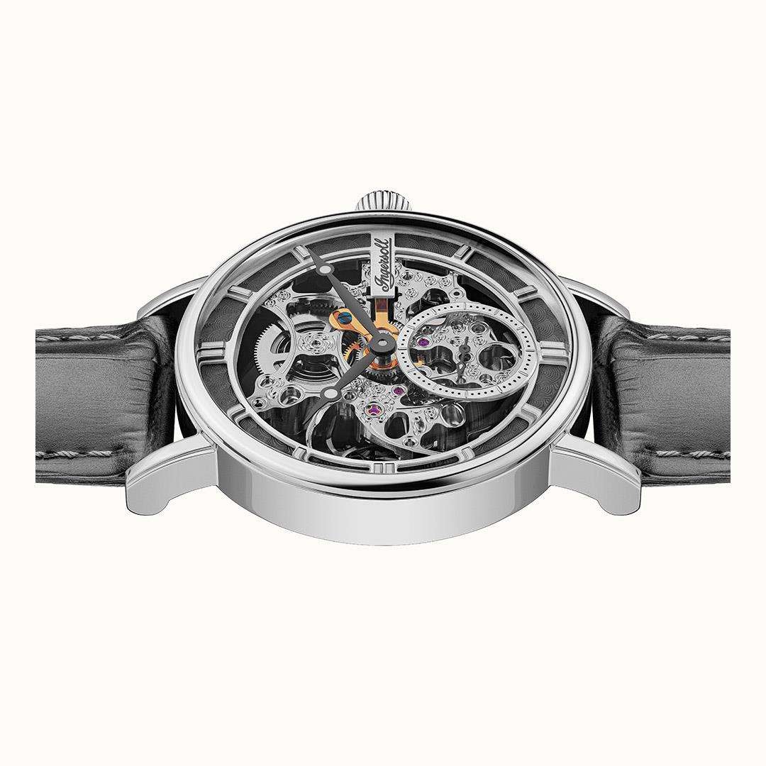 Angled view of skeleton watch movement with colorful jewels and metallic gear bridges