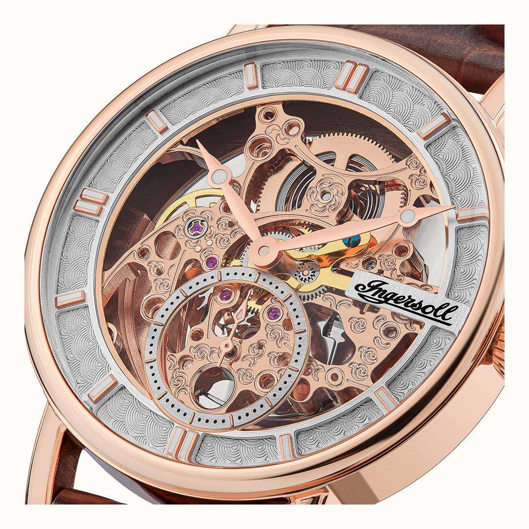 Silver skeleton watch dial close-up with ornate mechanical movement and brown case rim