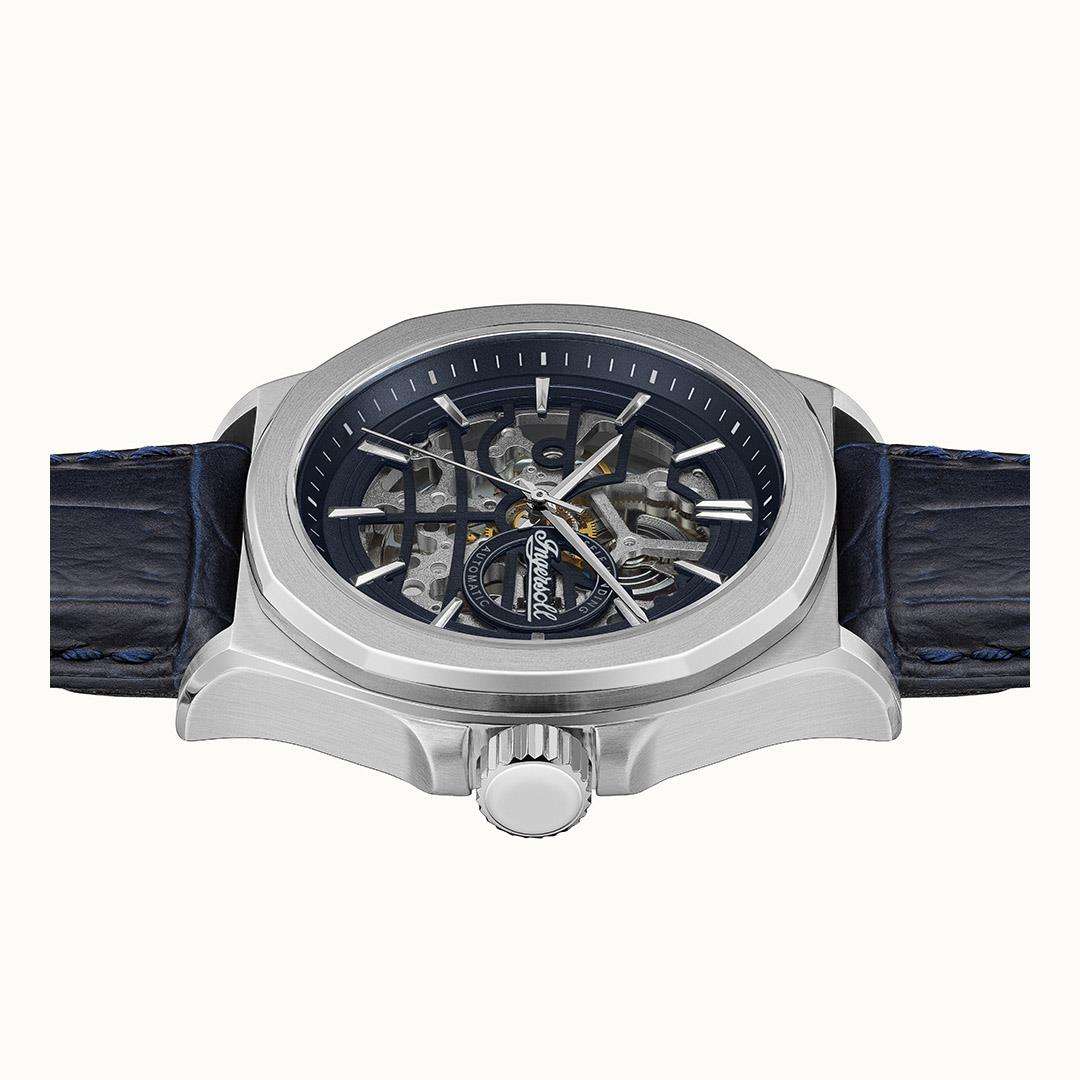Men's automatic watch front view with navy leather strap and visible internal gears through dial.