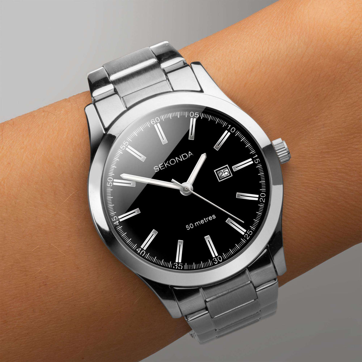 Ladies stainless steel watch on wrist with black dial, baton markers, date window 25.