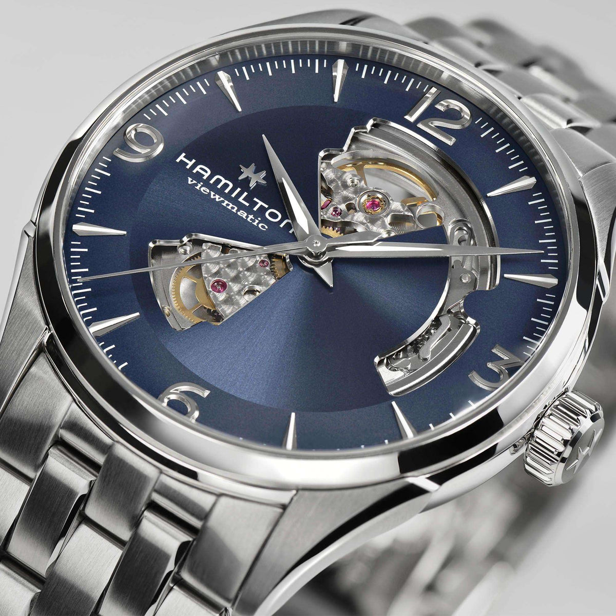 Hamilton Jazzmaster H32705141 42mm watch close-up detail highlighting blue dial cutout, visible balance wheel, and silver hands