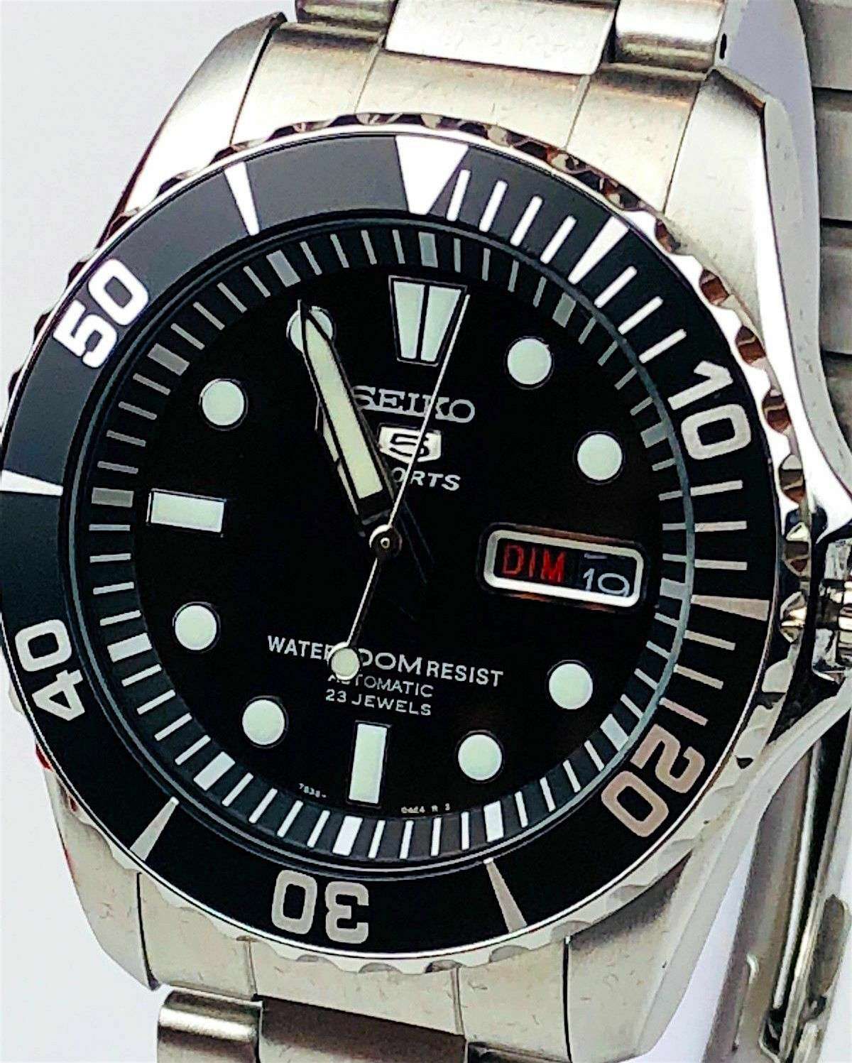 Close-up of black dial automatic men’s watch with dive bezel, bezel numerals, and date window
