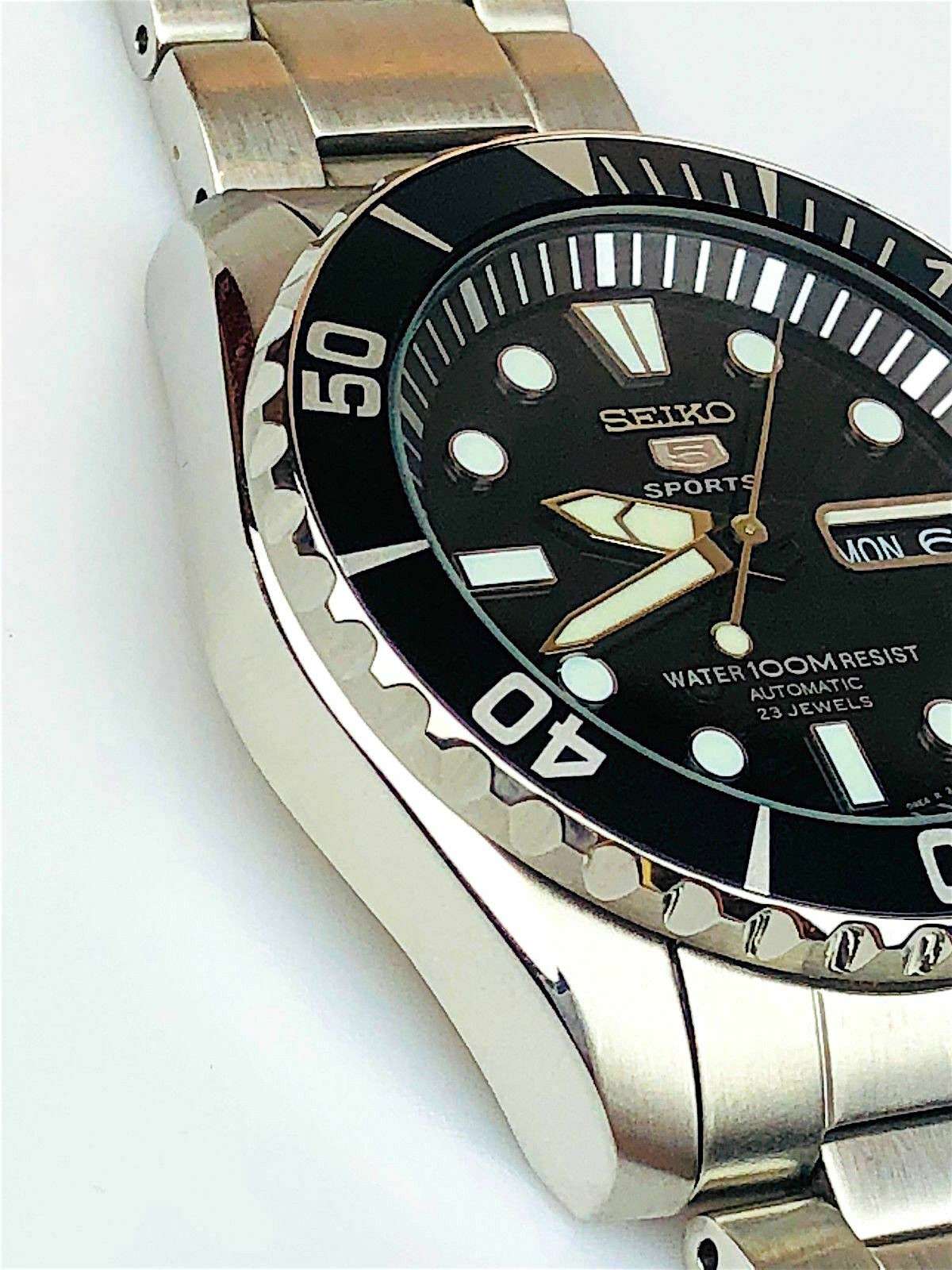 Side view of stainless steel men’s dive watch with black dial and ridged bezel edge