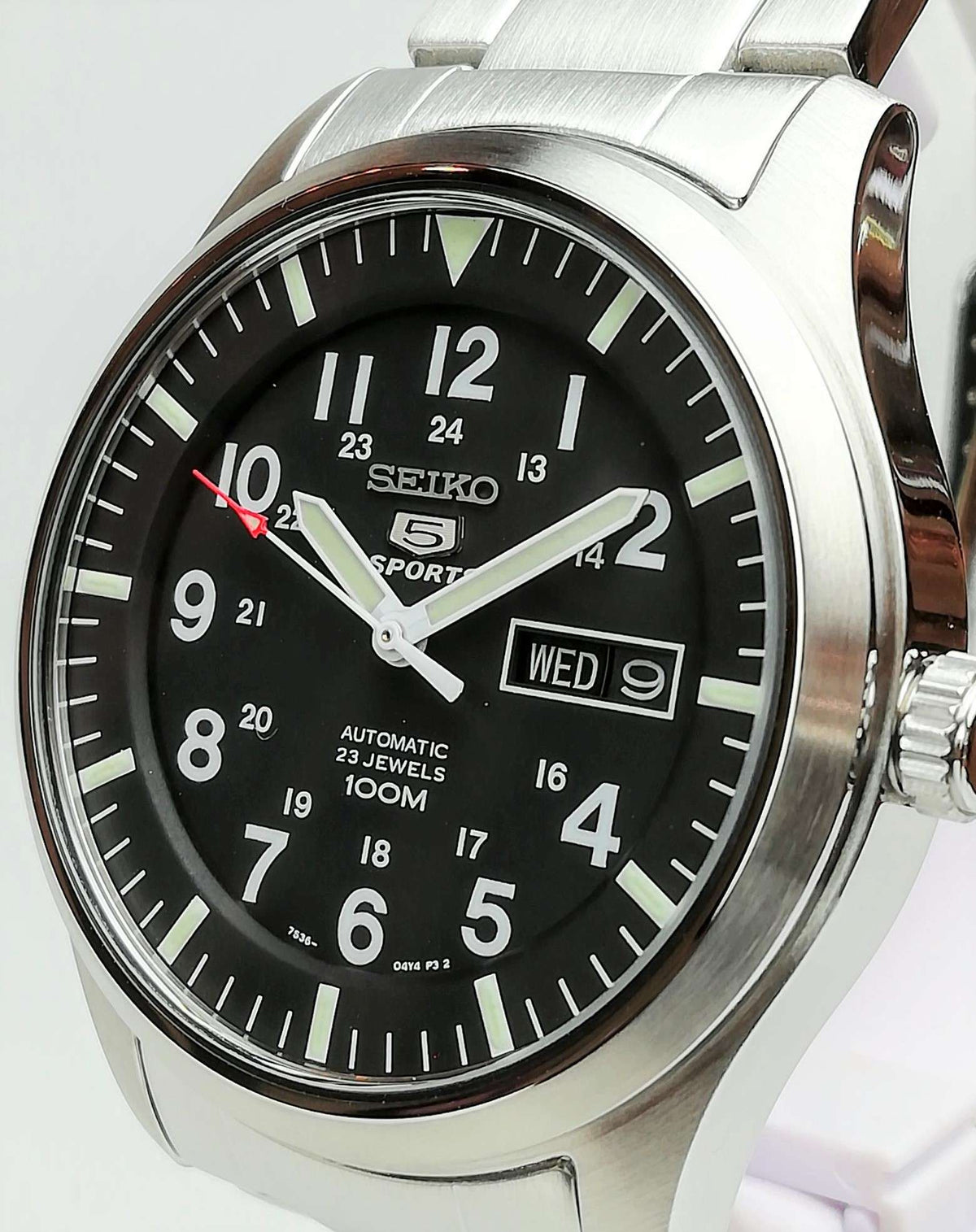 Men's Seiko 5 Sports watch closeup: black dial, day-date window, on steel case