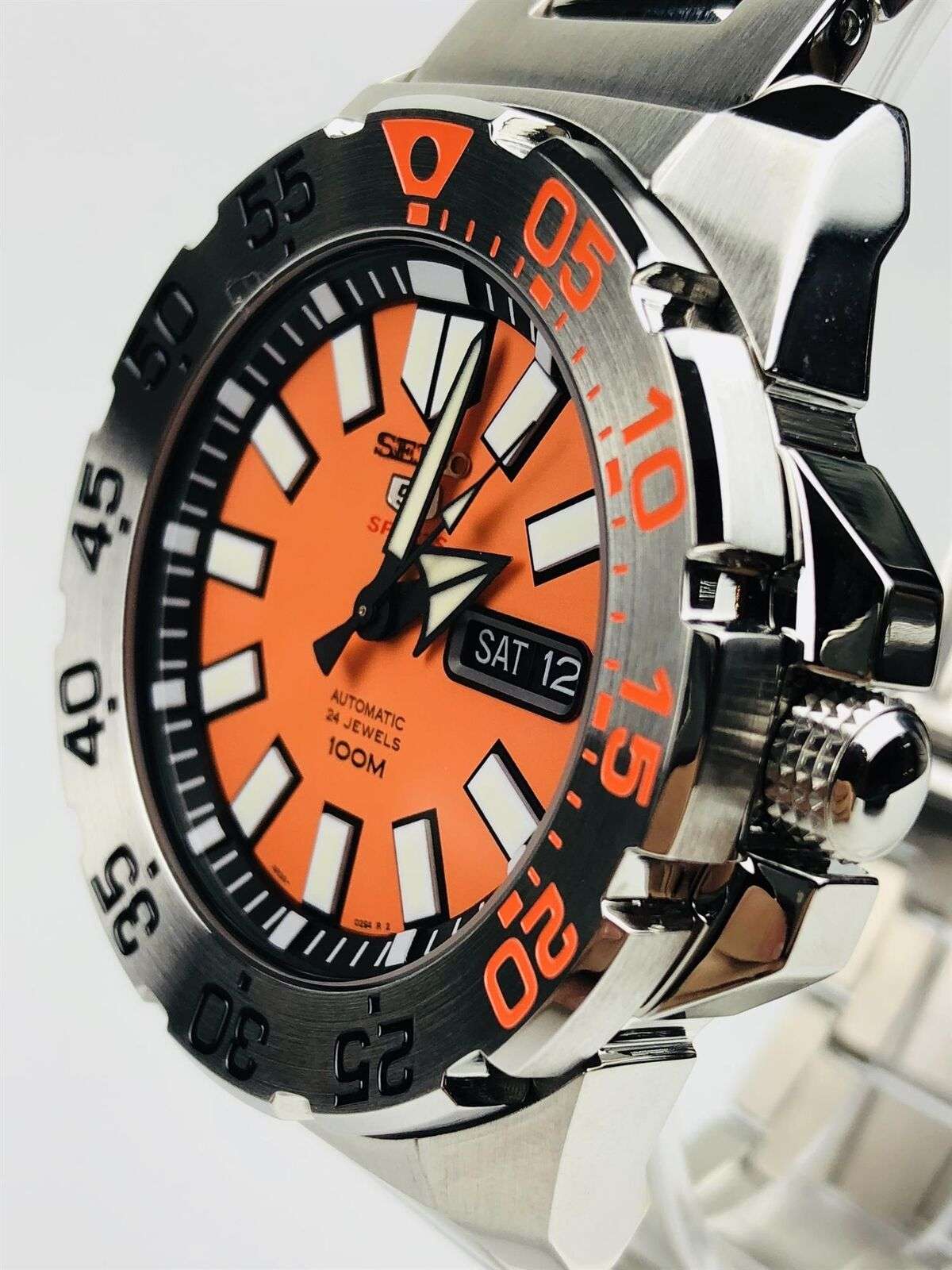 Orange dial stainless steel diver watch with black bezel, crown side detail, and date window