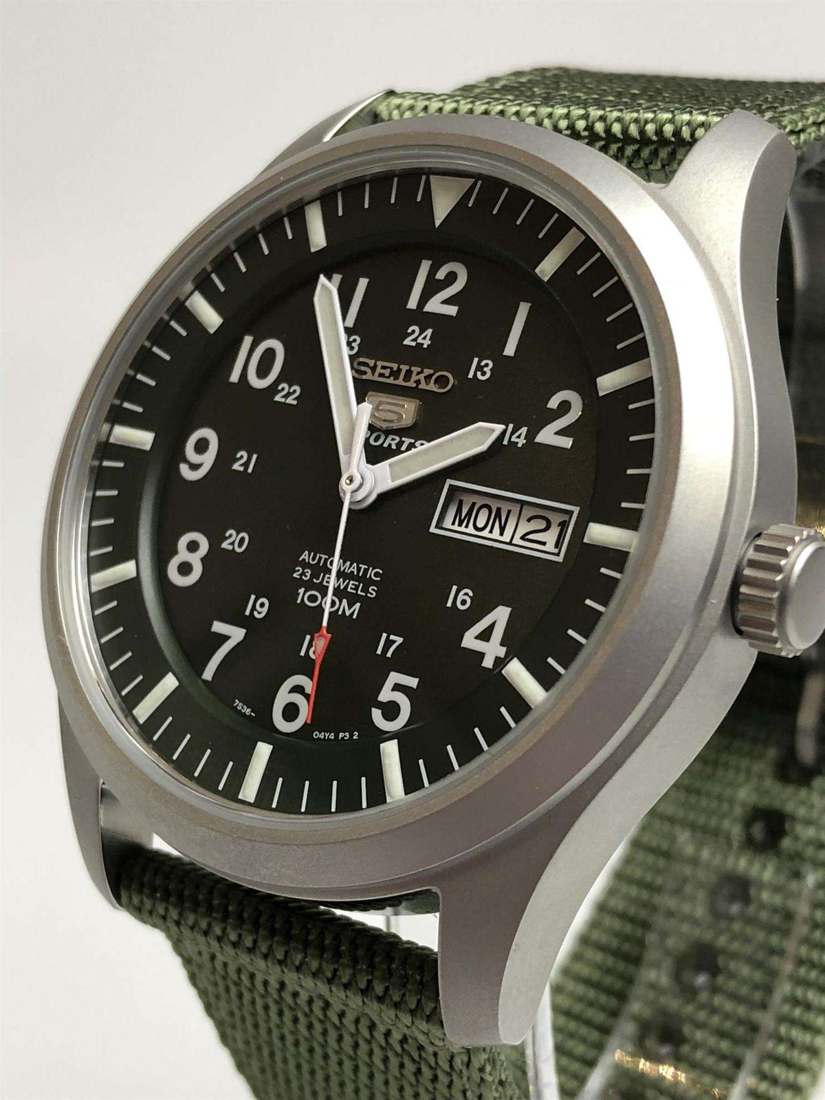 Men's automatic watch shown in profile with green dial, green fabric strap