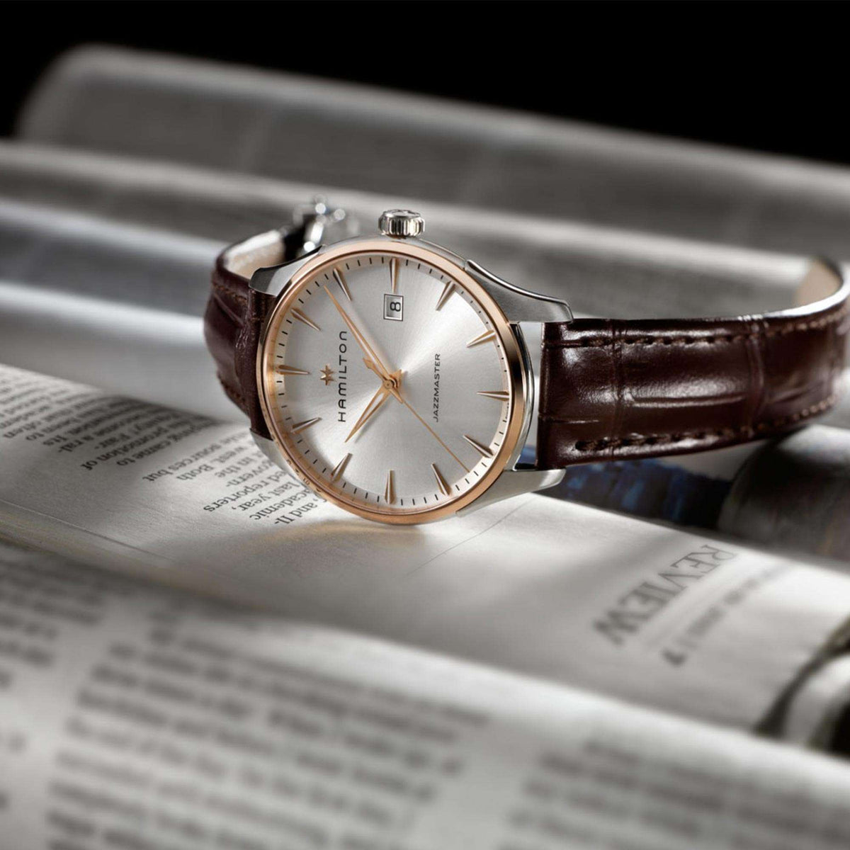 Quartz wristwatch angled view with silver case, light dial, and brown leather strap