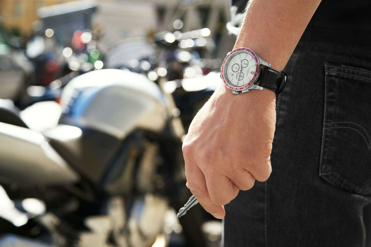 Men's wristwatch with white dial and black leather strap, worn on wrist
