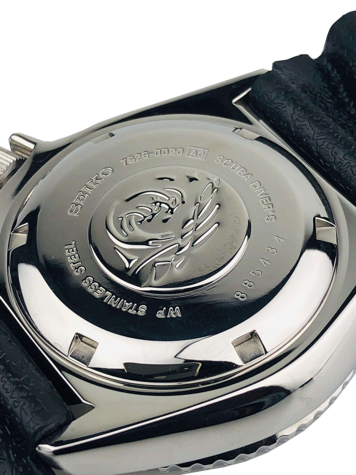 Seiko diver watch caseback with engraved fish emblem on steel back, black rubber strap