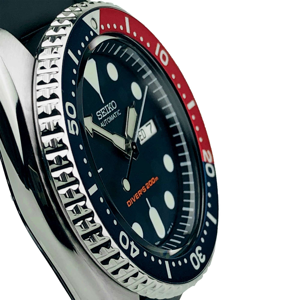 Seiko diver watch side close-up with blue/red bezel and black dial with luminous markers