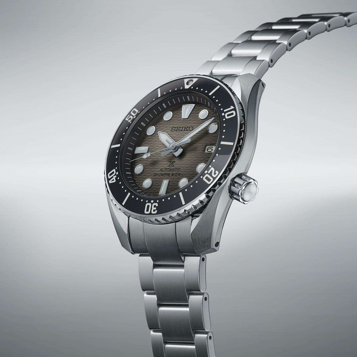 Automatic steel divers watch angled side view, grey dial, black bezel, crown, bracelet