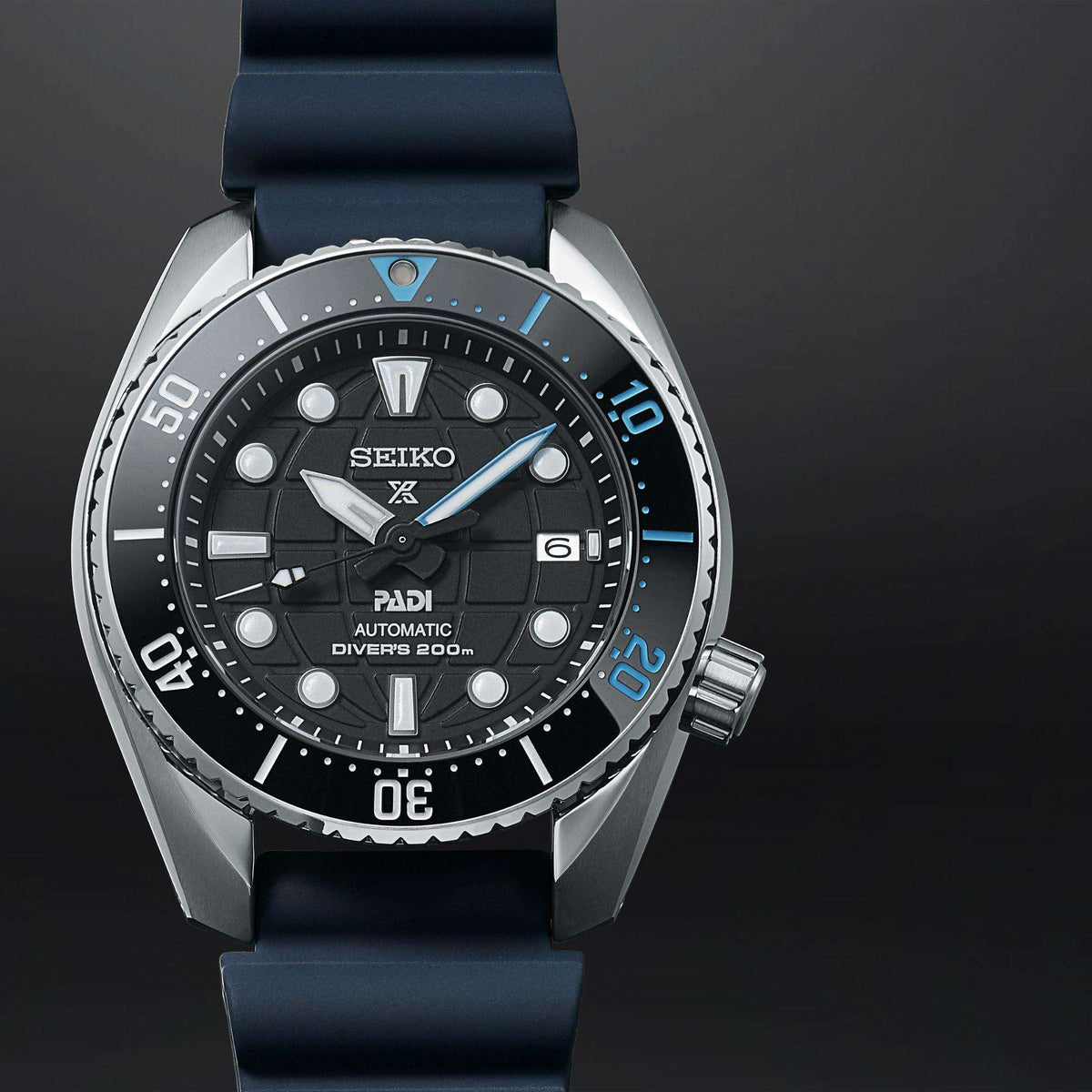 Seiko Prospex diver watch close-up with black dial, blue silicone strap, steel bezel