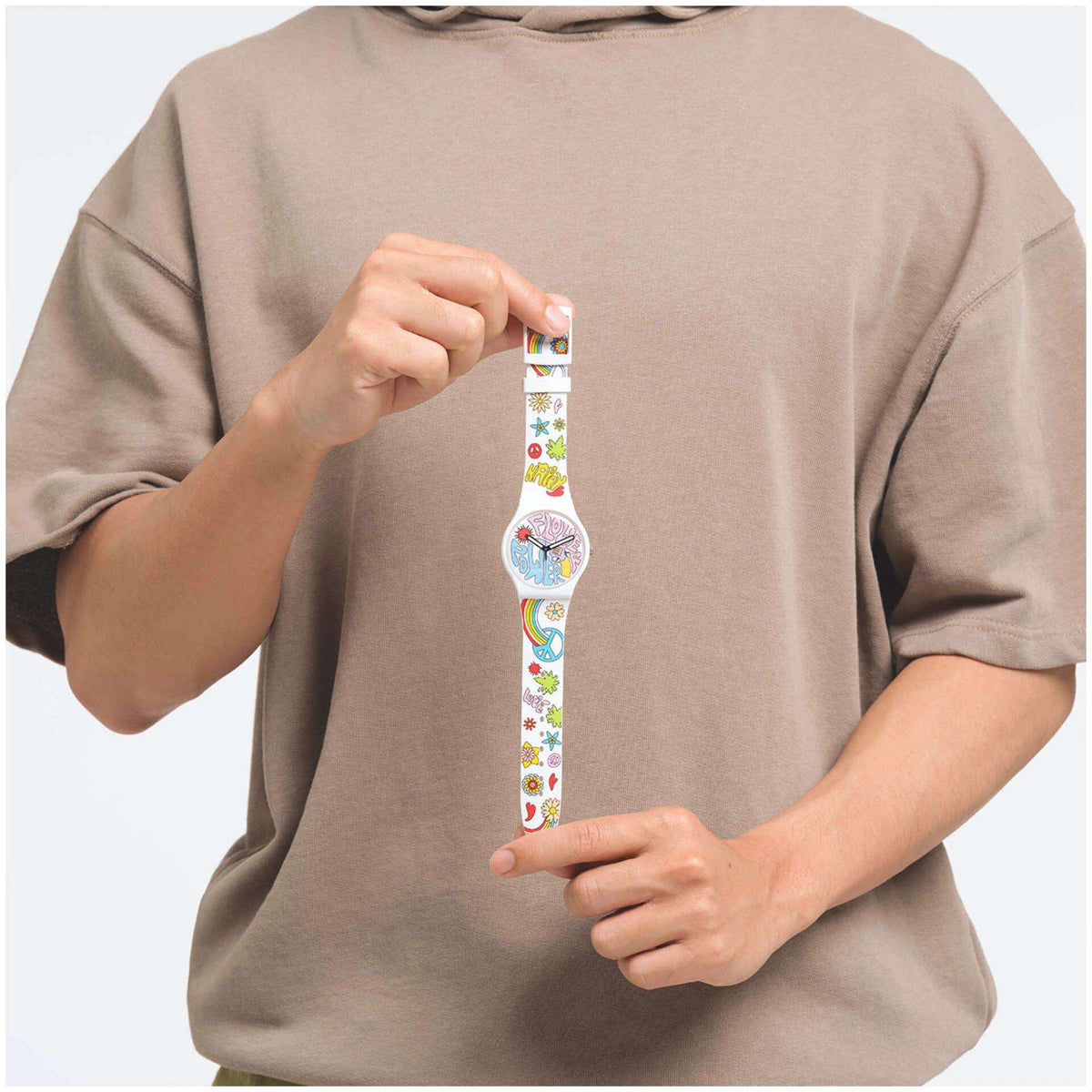 Swatch silicone quartz watch on raised wrist, patterned multicolour strap