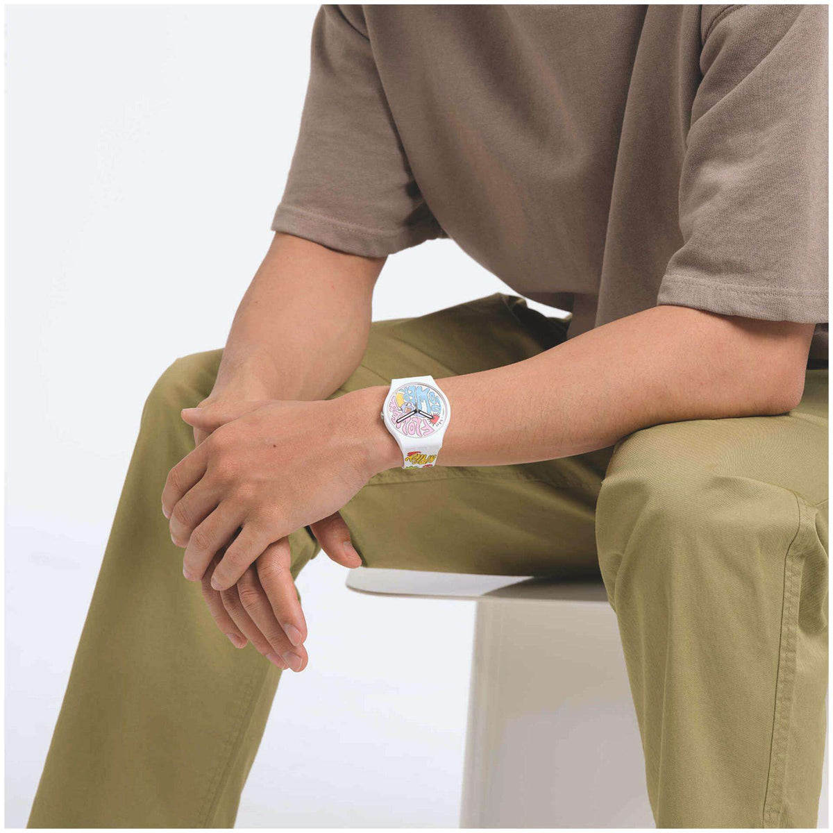 Swatch silicone quartz watch worn on wrist with multicolour dial