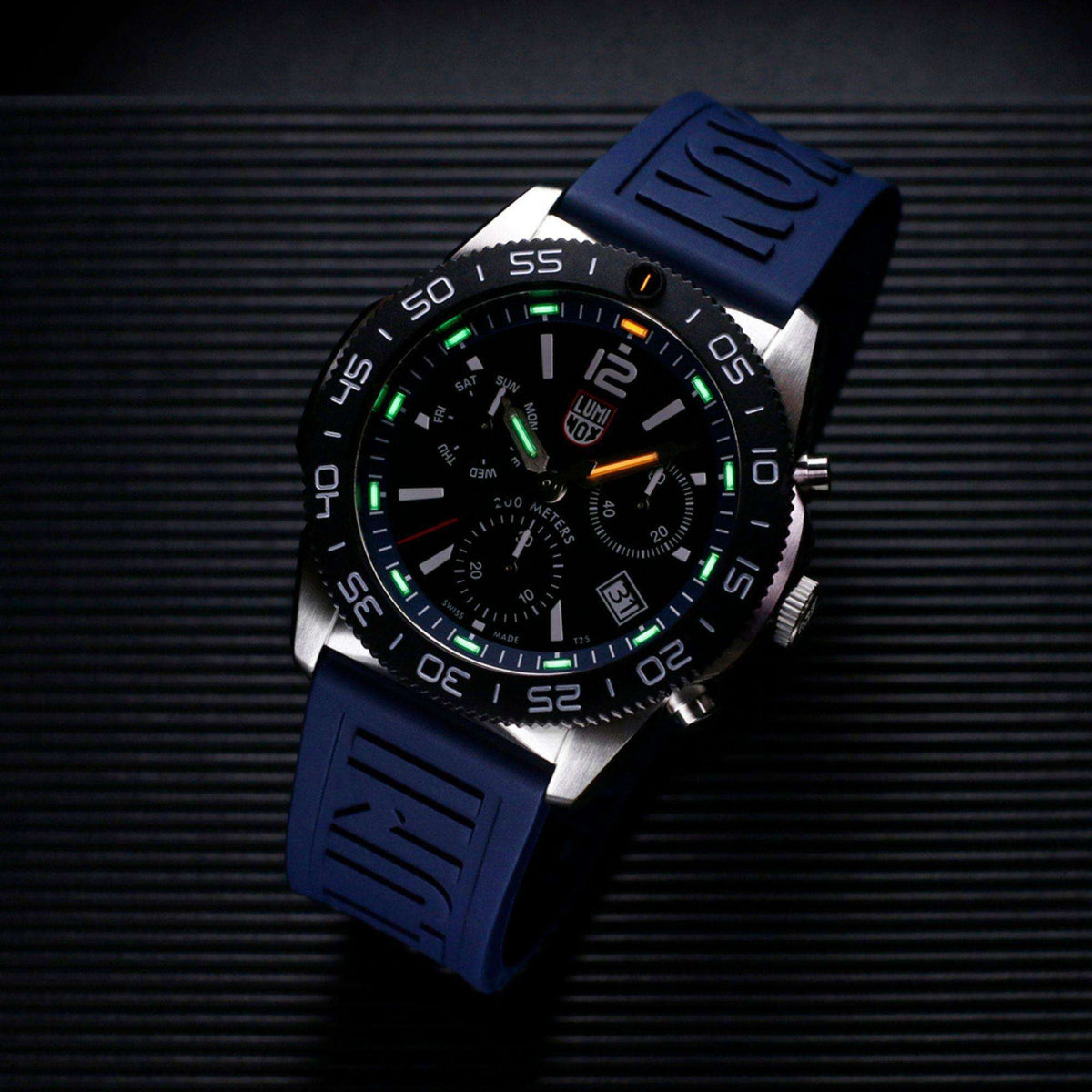 Black chronograph diver watch with blue rubber strap, luminous markers, and three subdials