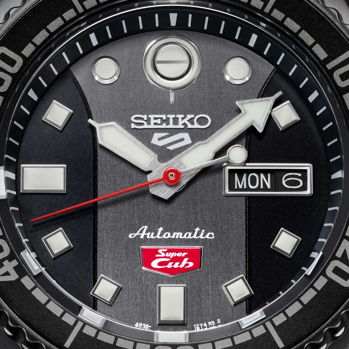 Men’s automatic diver watch dial close-up with red seconds hand and MON 6 date