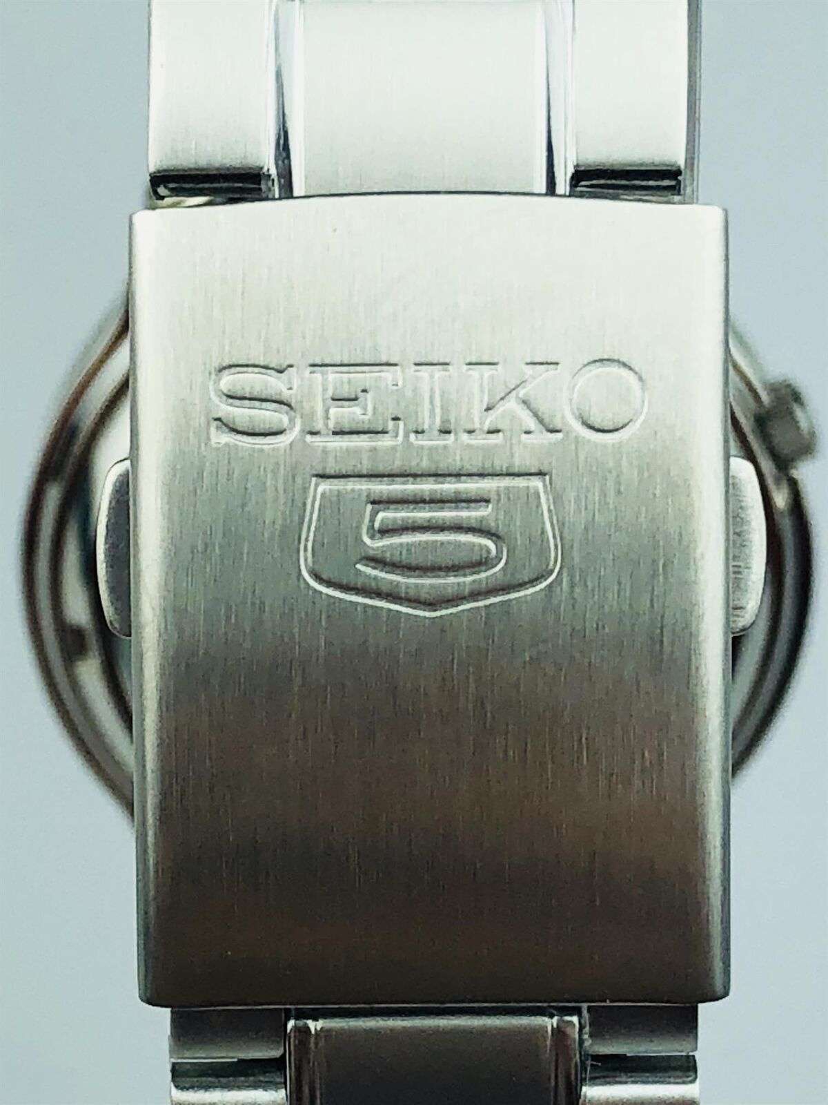 Stainless steel watch clasp with SEIKO logo engraving on metal bracelet link.