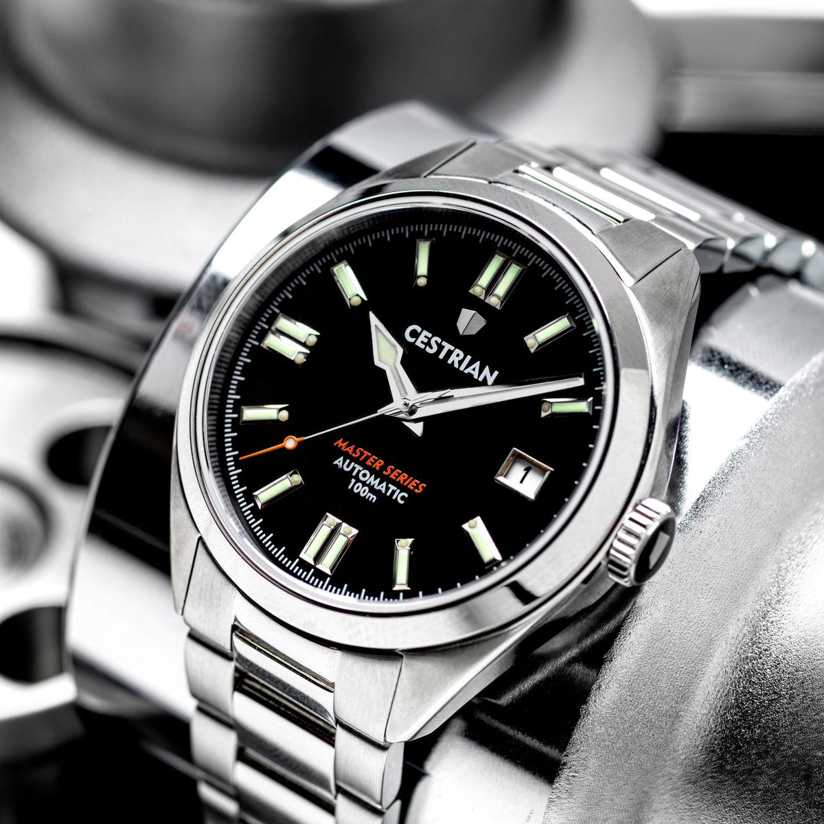 Automatic men’s watch close-up with black dial, glowing markers, and date at 1