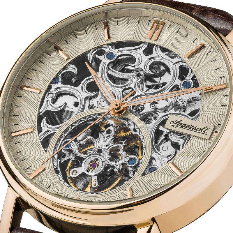 Close-up of men's Ingersoll skeleton dial with metallic gears and brown leather strap