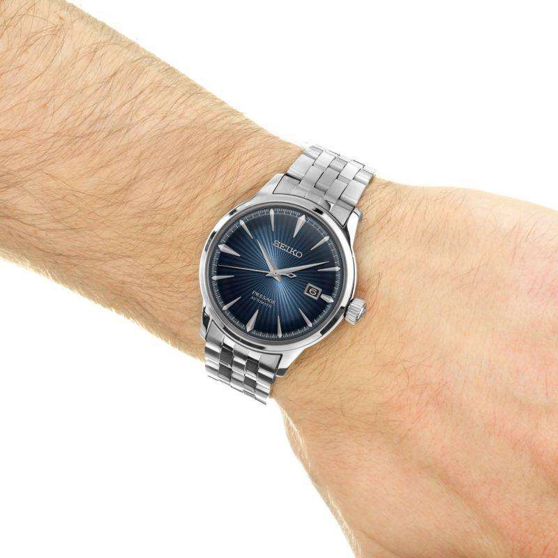 Seiko men's watch on wrist with blue sunburst dial and silver stainless bracelet