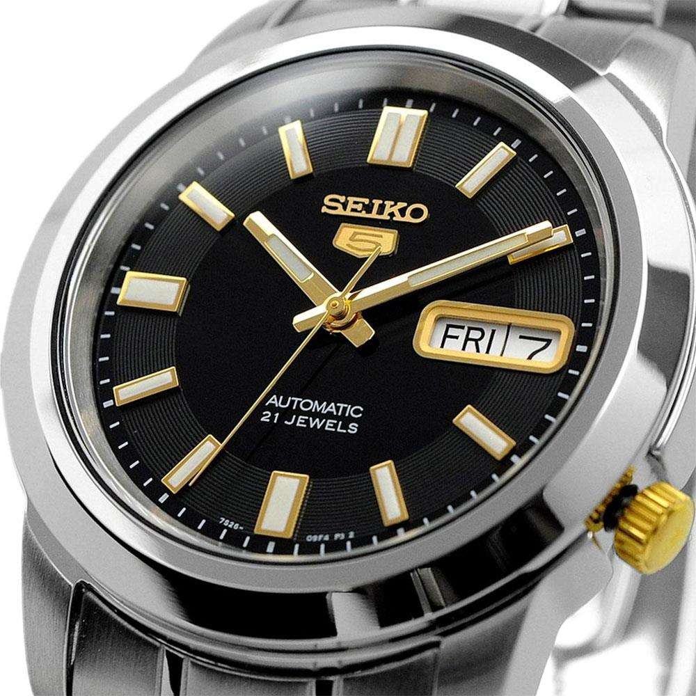 Automatic wristwatch close-up: black dial with gold hands and markers, day/date window