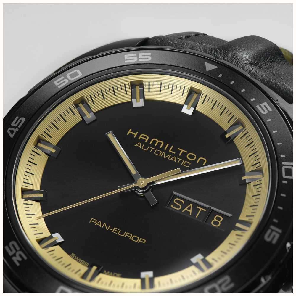 Hamilton automatic watch close-up with black dial, gold accents, and date window