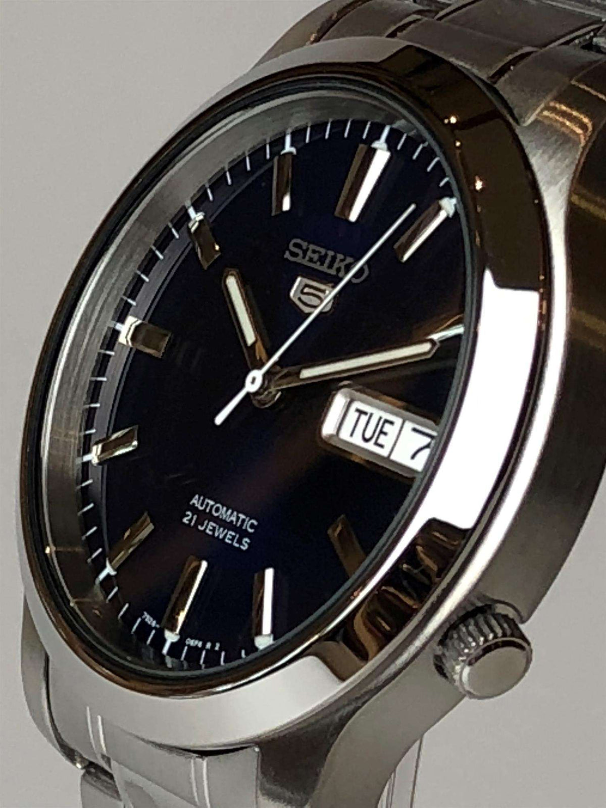 Men's steel automatic watch side view with blue dial and date window TUE