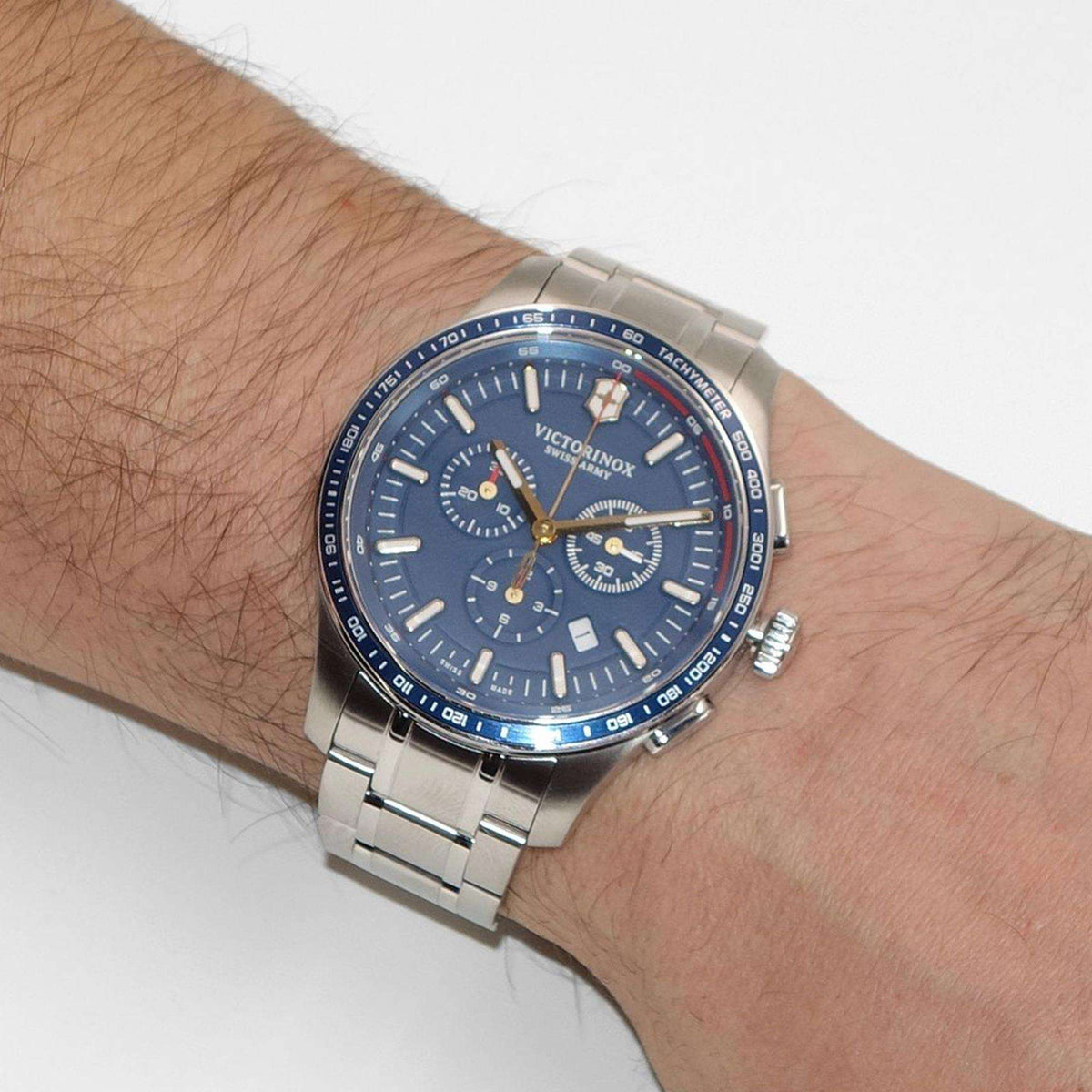 Men's stainless steel chronograph watch on wrist with blue dial and subdials
