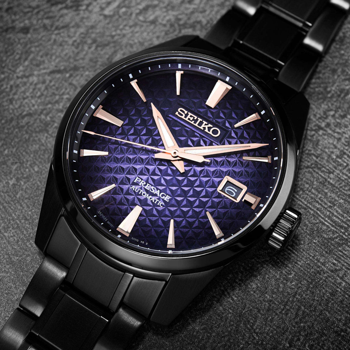 Men's blue textured dial automatic watch close-up with rose-gold hands and markers