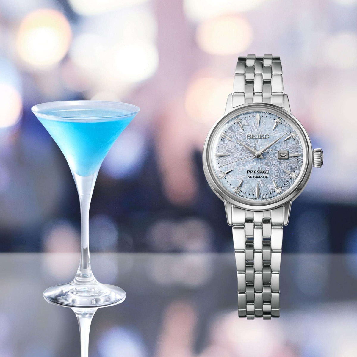 Seiko Presage SRE007J1 front view next to a blue cocktail glass