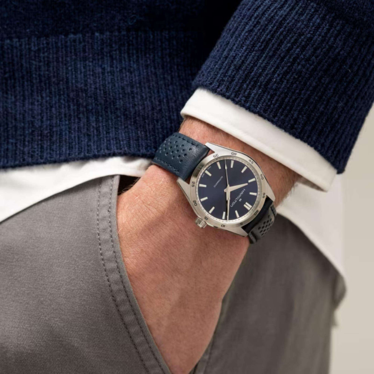 Men’s wrist watch with blue dial and dark leather strap worn on model