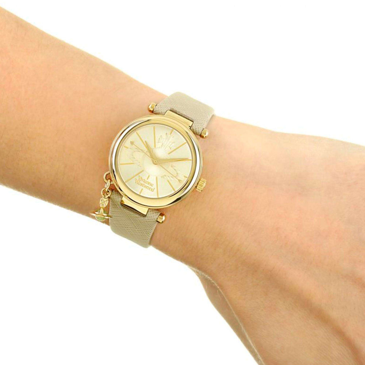 Ladies quartz wristwatch on wrist with gray leather strap and gold-tone bezel