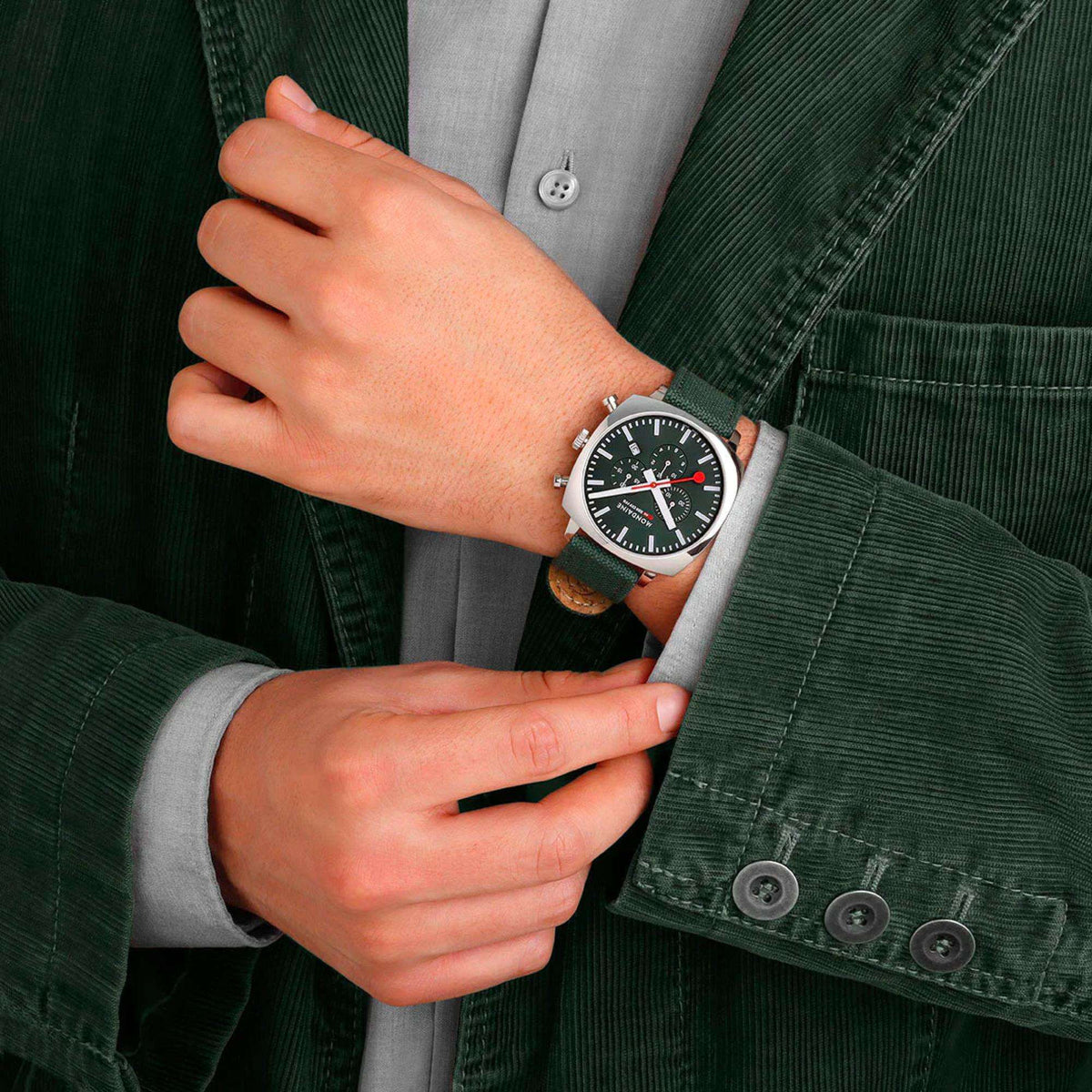 Men's chronograph watch on wrist with green dial, silver bezel, and green strap
