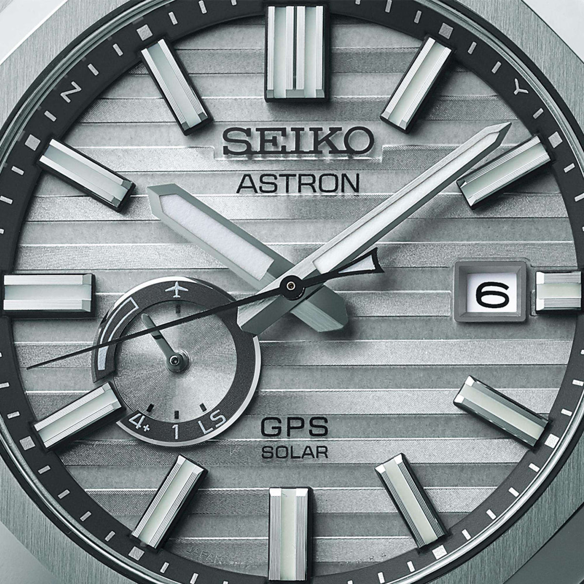 Close up view of the grey dial, highlighting the bold indices, lumibrite hands, date aperture, and the small GPS indicator sub-dial.