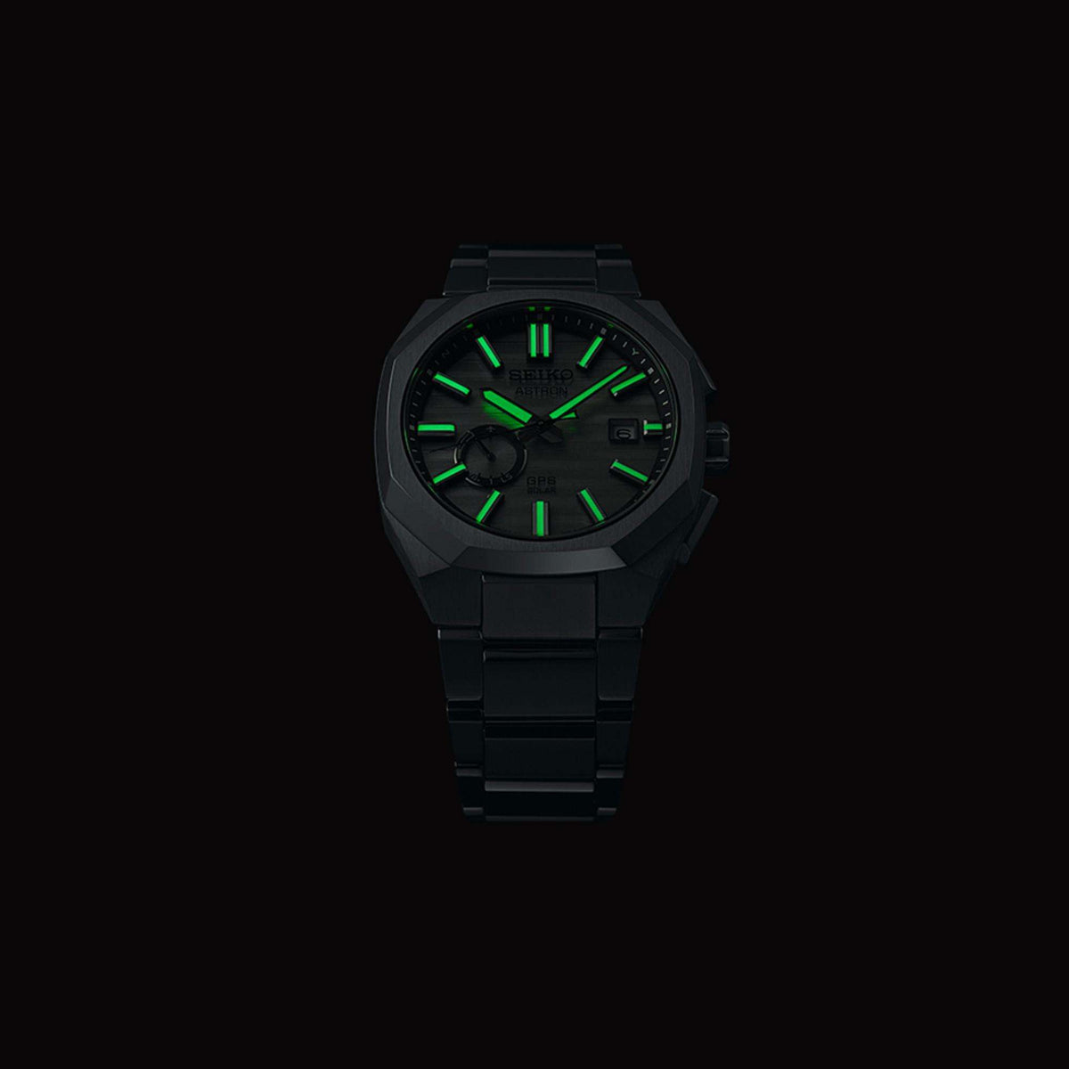 Lume shot of the watch in complete darkness, showing the bright green luminescent glow on the hands and hour markers.