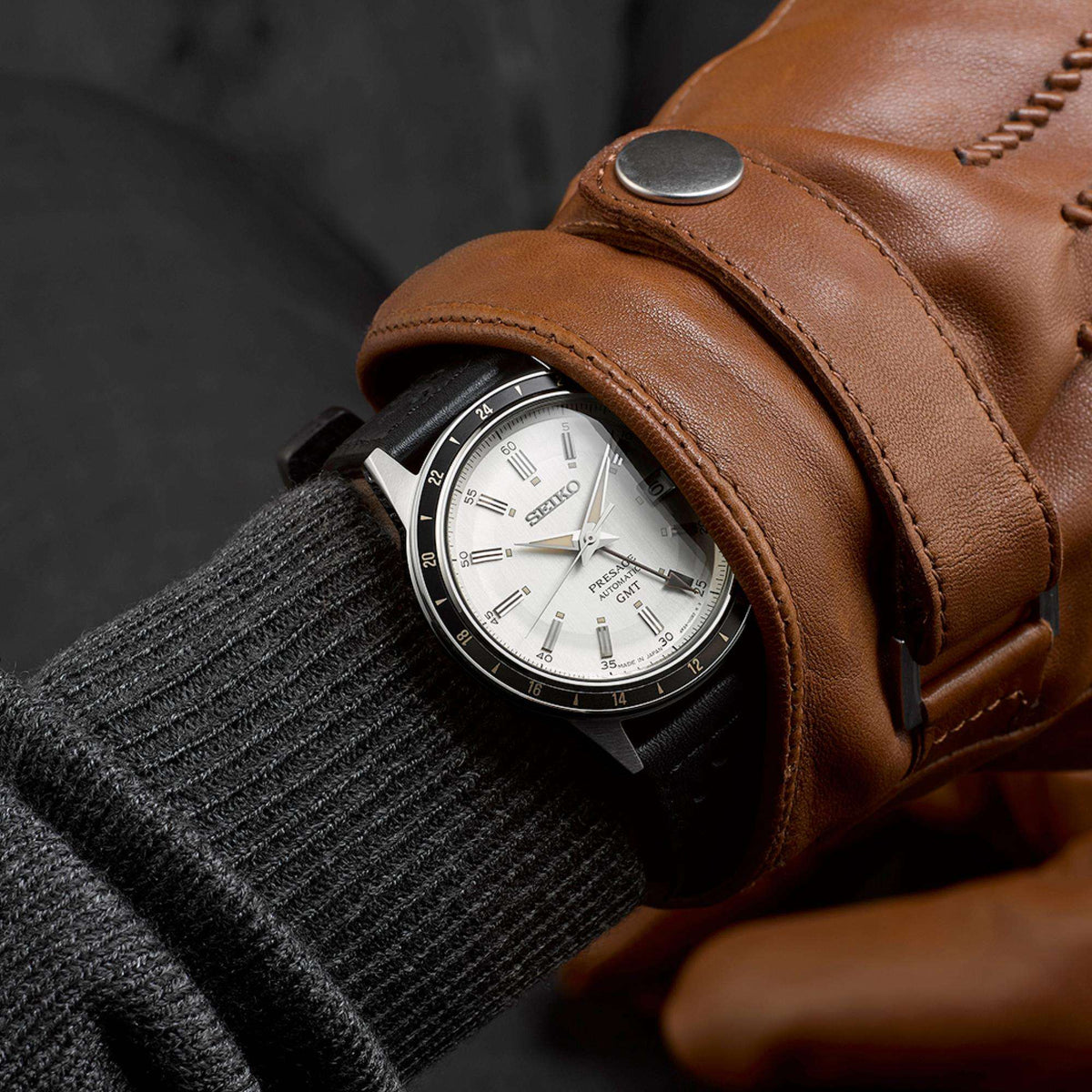 Seiko Presage Stone Style 60s Road Trip GMT SSK011J1 on-wrist view with grey sweater and brown leather driving glove