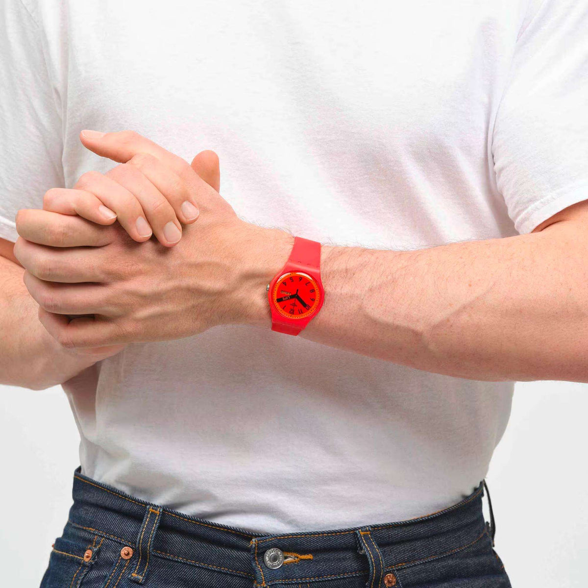 Red unisex quartz wristwatch on a person’s arm, red dial and matching silicone strap.